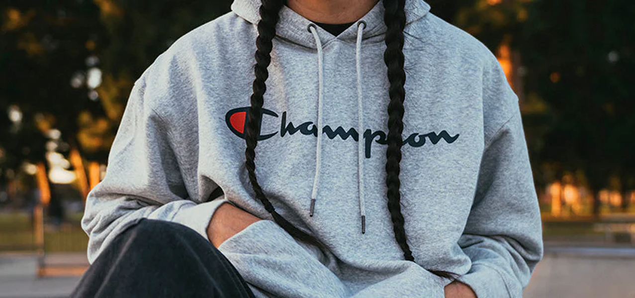 Photograph of model wearing a gray champion hoodie
