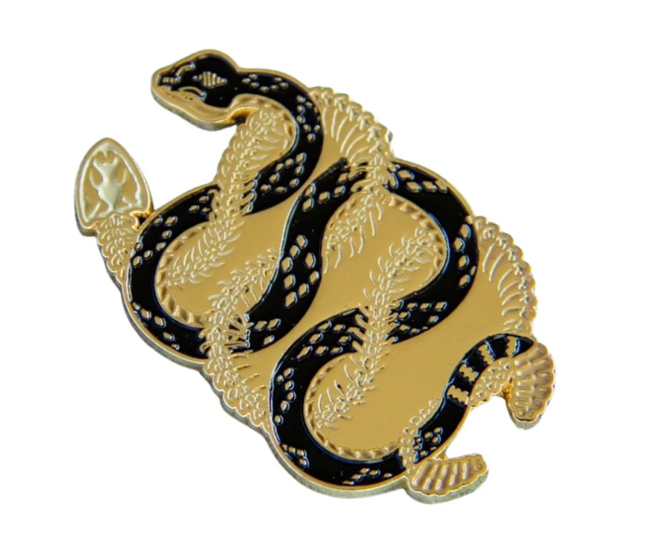 Soft enamel pin of two snakes intertwining.