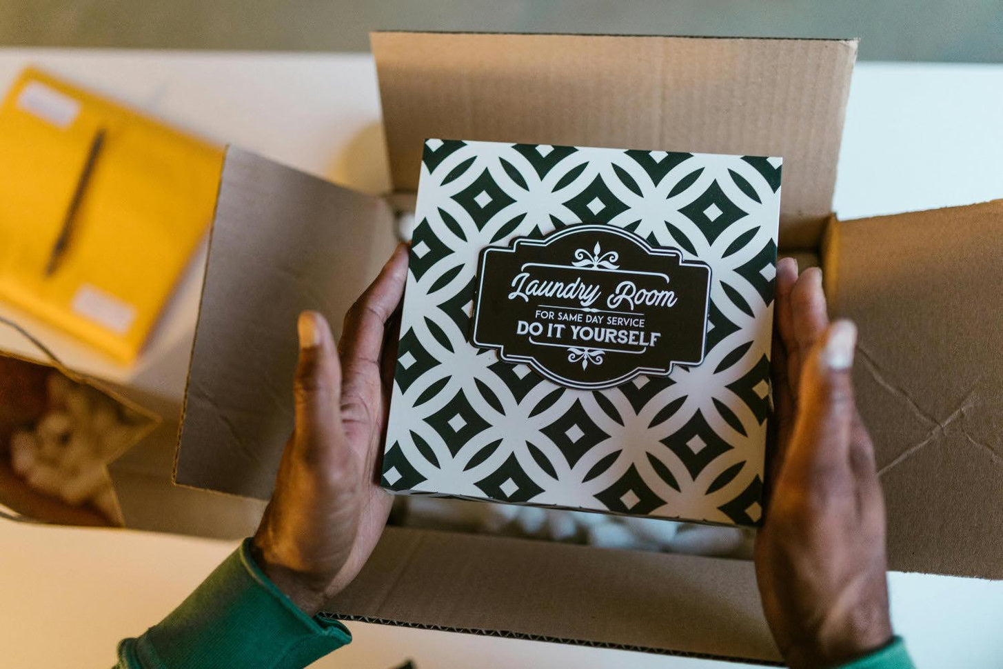 A person pulls a packaged product out of a shippng box