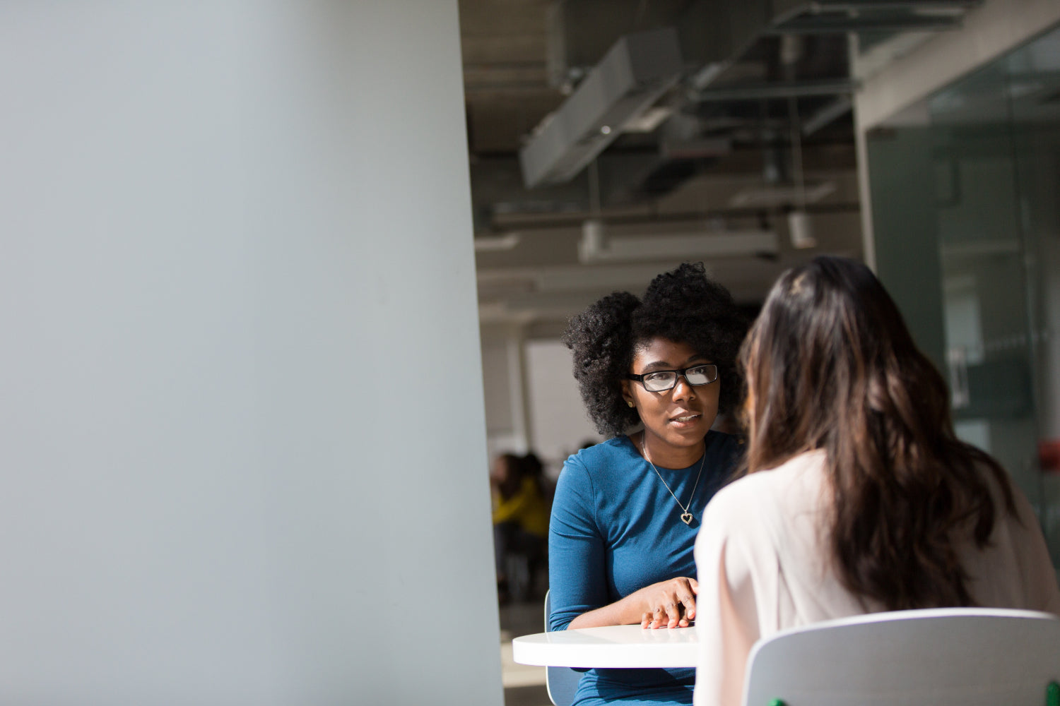 Two women talk in a cafe setting