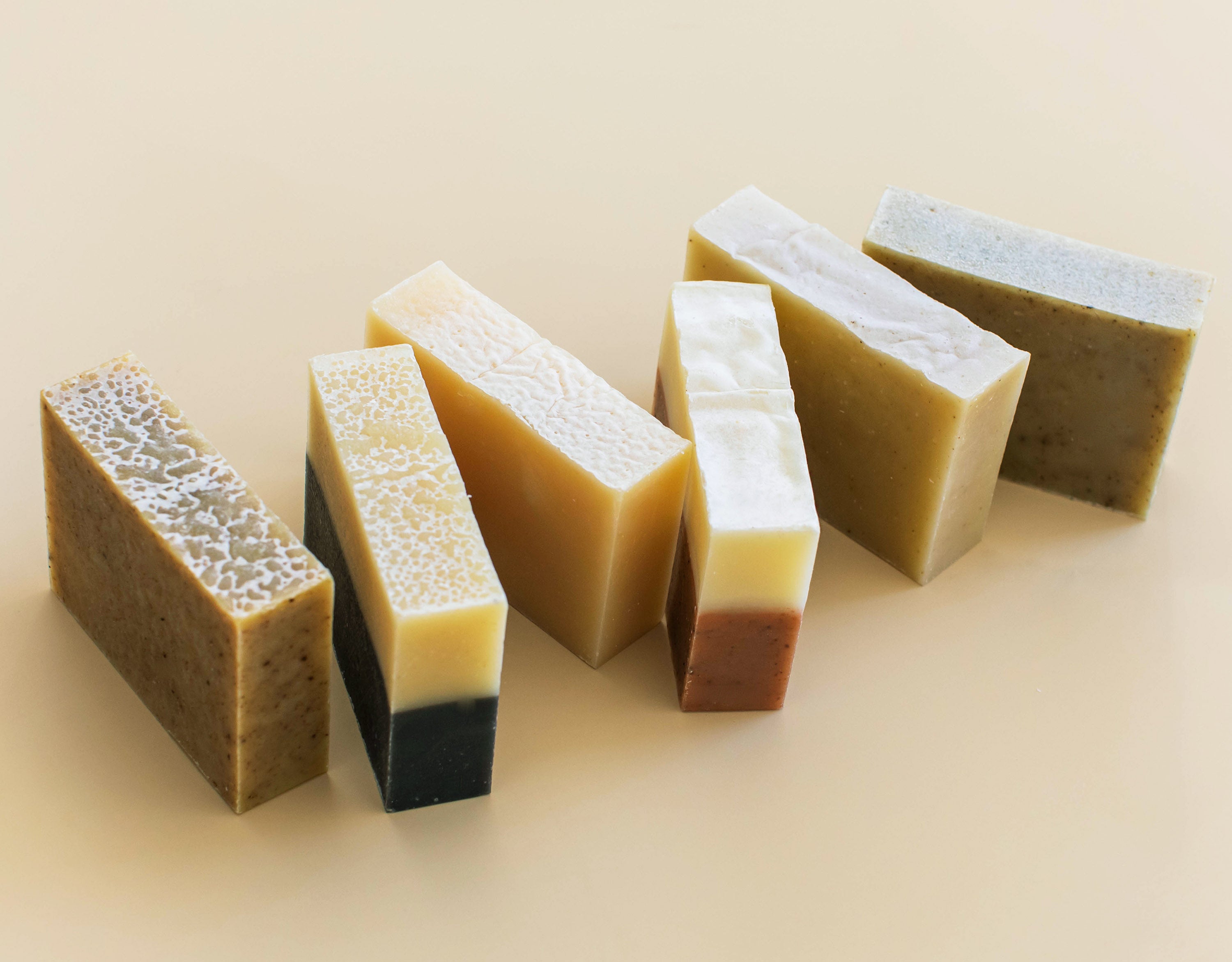 an array of unpackaged soap on a cream background