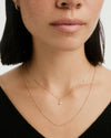 Woman wearing a Baby Box Chain Necklace, highlighting its elegant fashion accessory style around her neck, with a close-up on her lips for context.
