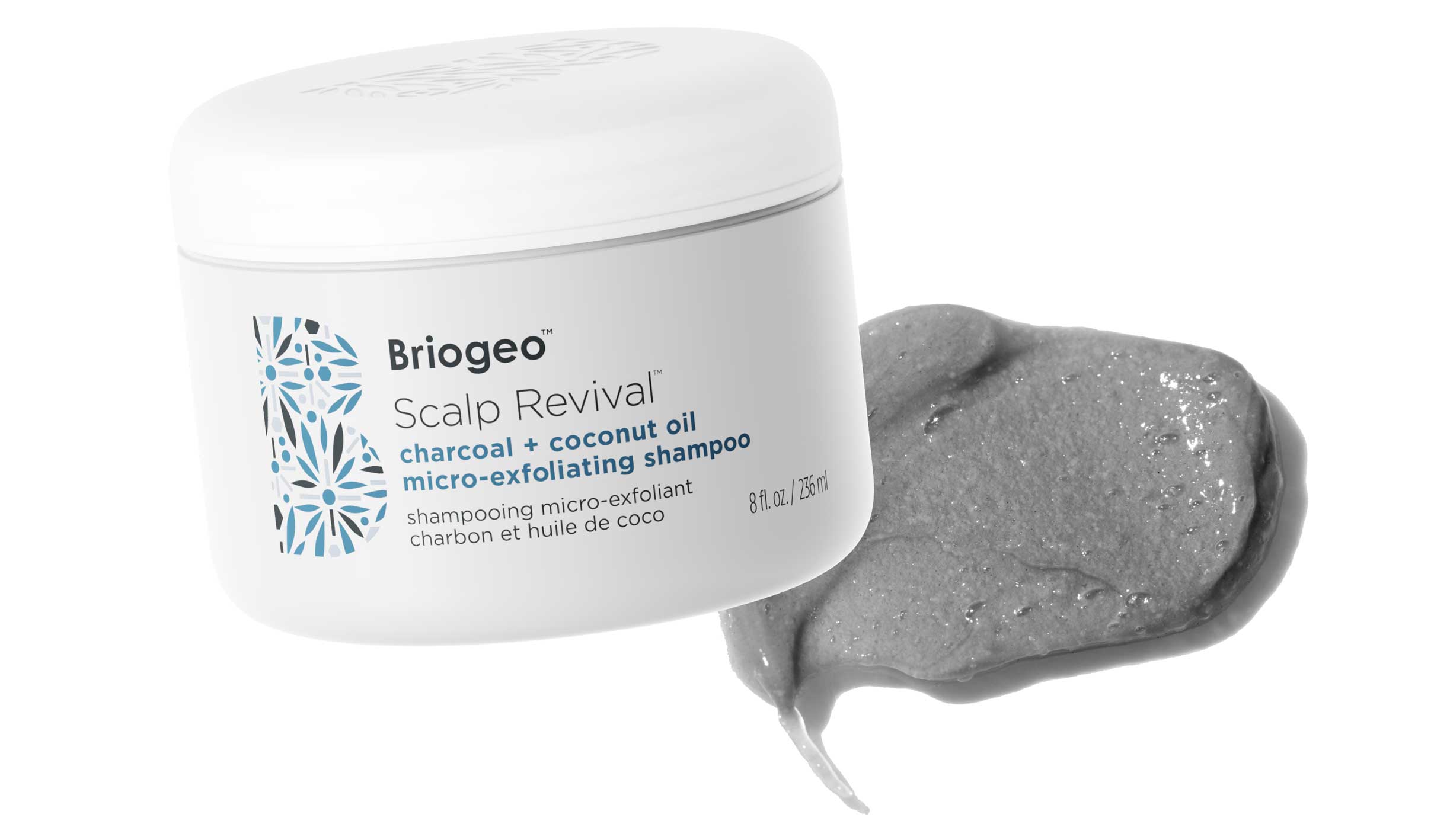 Briogeo Scalp Revival Exfoliating Scalp Scrub in front of a grey, whipped textured swatch.