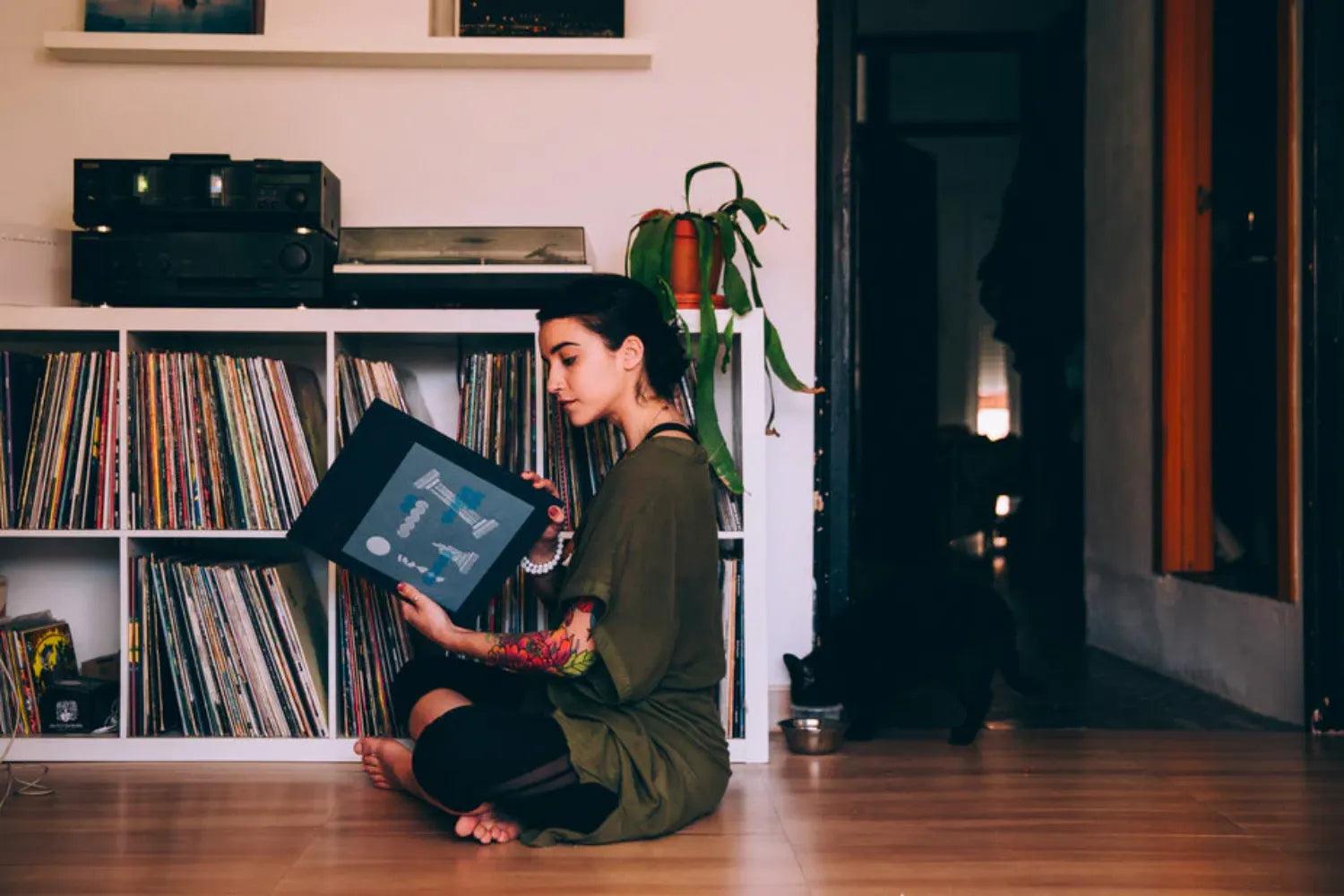 donna seduta sul pavimento con in mano un disco in vinile: cosa vendere online